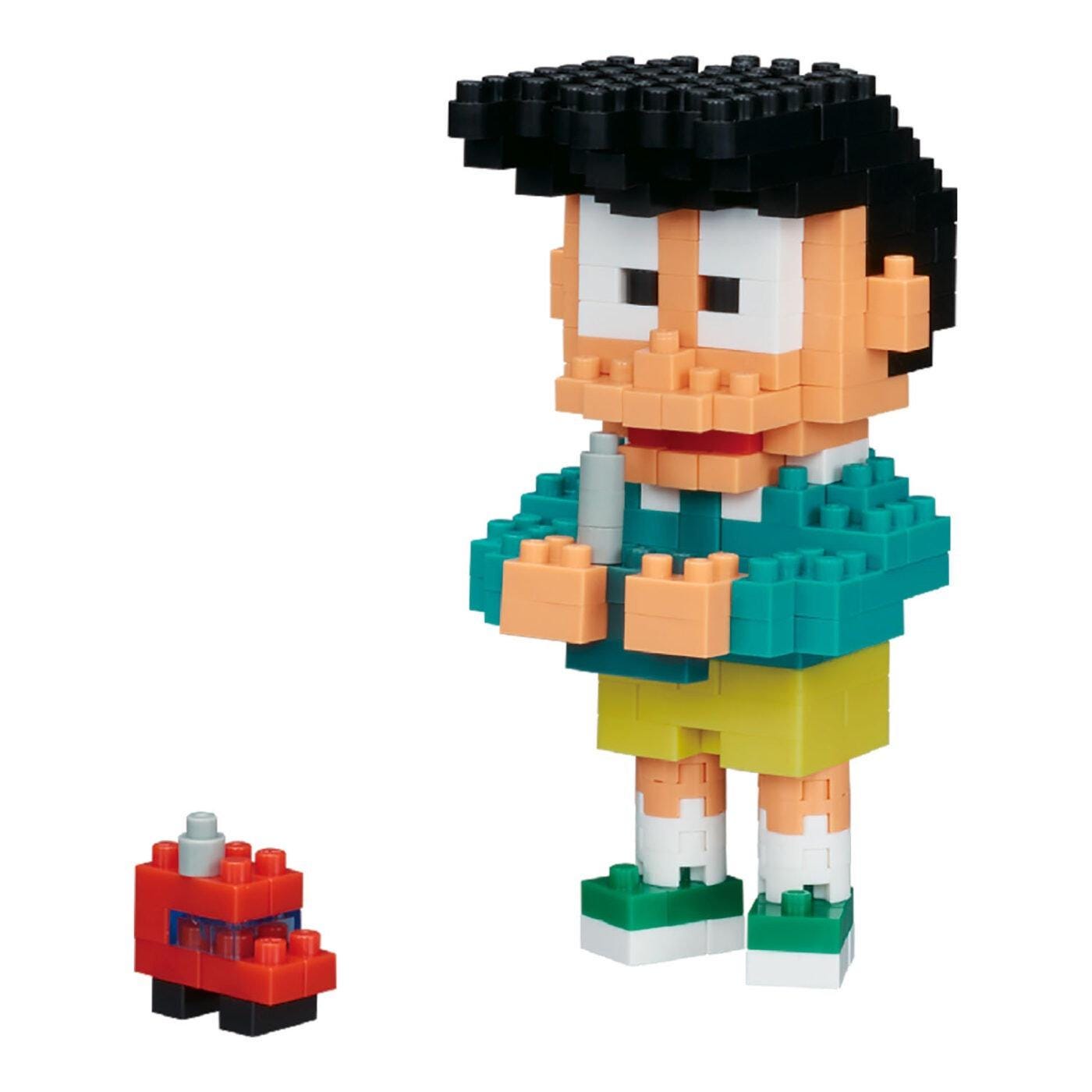 A small red toy car next to a toy figure of a boy wearing a green shirt and yellow shorts.