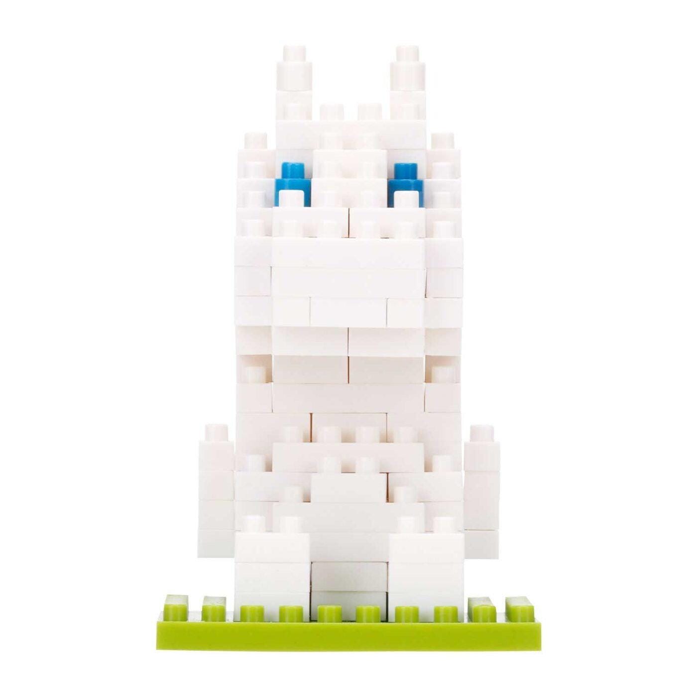 A white Lego bunny with blue eyes is sitting on a green base.