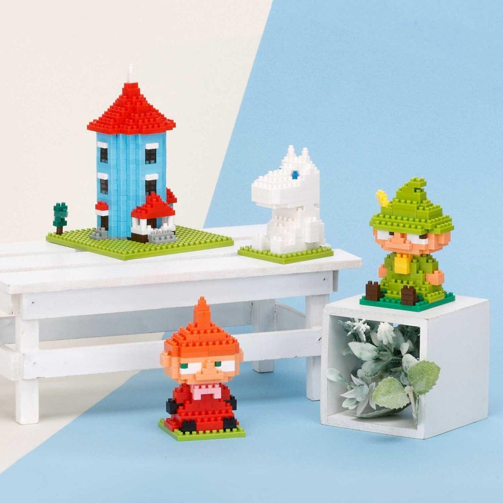 a collection of colorful, small, and whimsical building blocks and figurines arranged on a white surface.