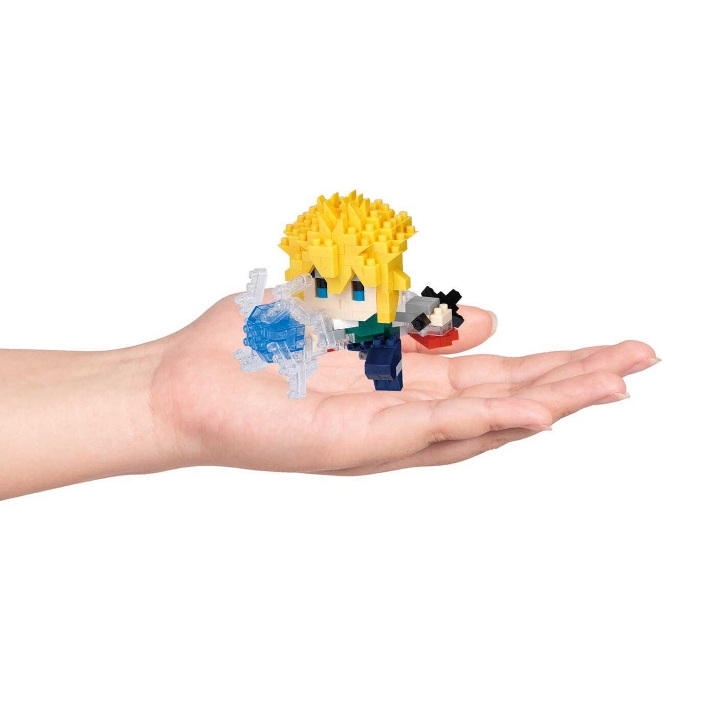 A hand holding a small, colorful, and intricate toy figure.