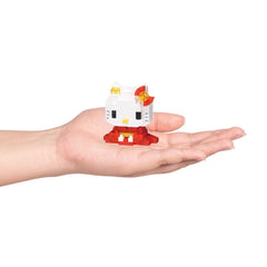 A hand holding a small white Hello Kitty figurine against a white background.