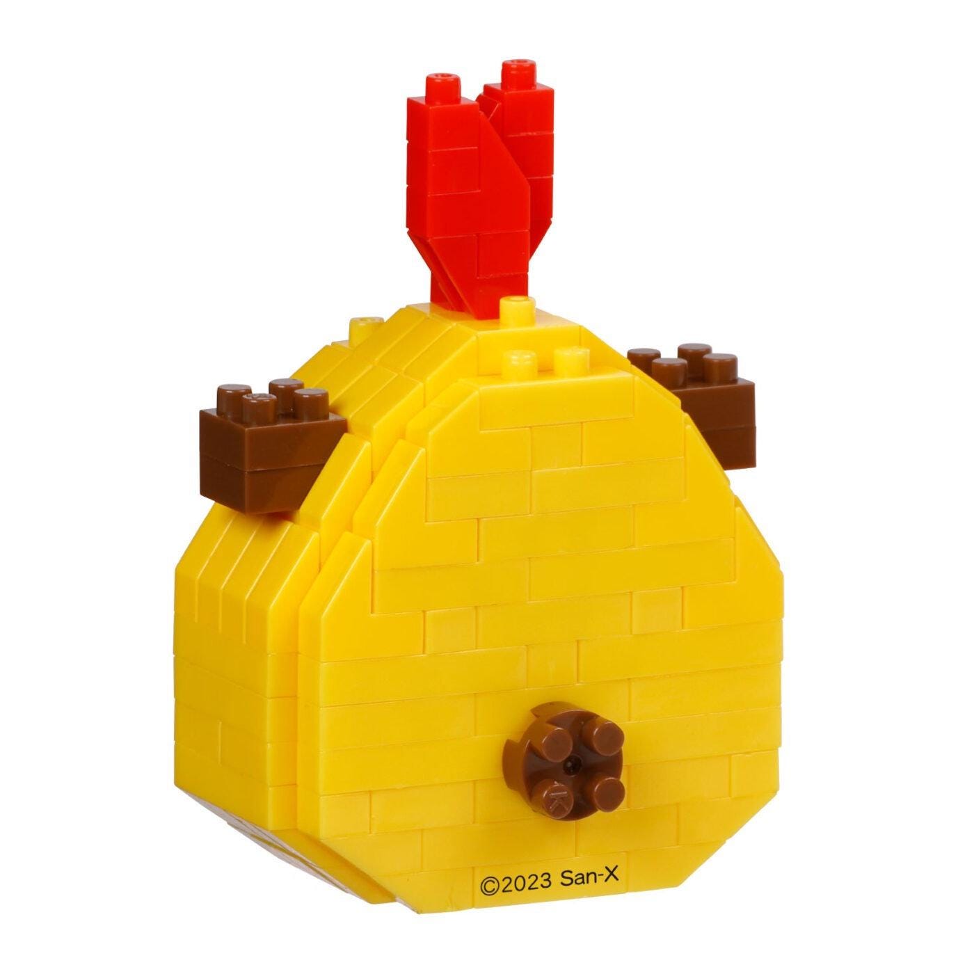 A yellow and red toy, resembling a building block or Lego structure, with a red piece on top and brown pieces on the sides.