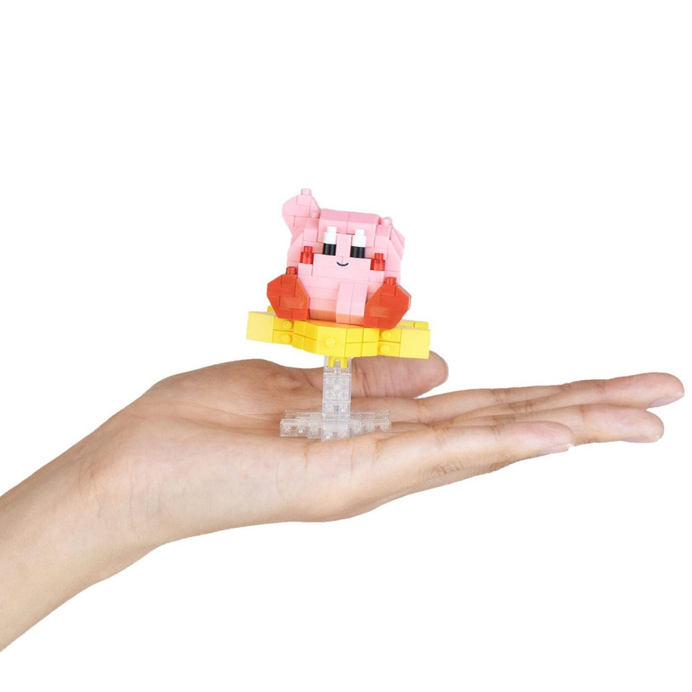 A hand holding a small pink and yellow toy figure.