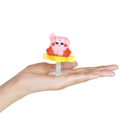 A hand holding a small pink and yellow toy figure.