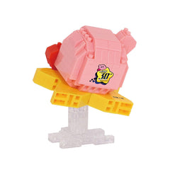 A pink and yellow toy figure with a yellow star on its back, sitting on a clear plastic stand.