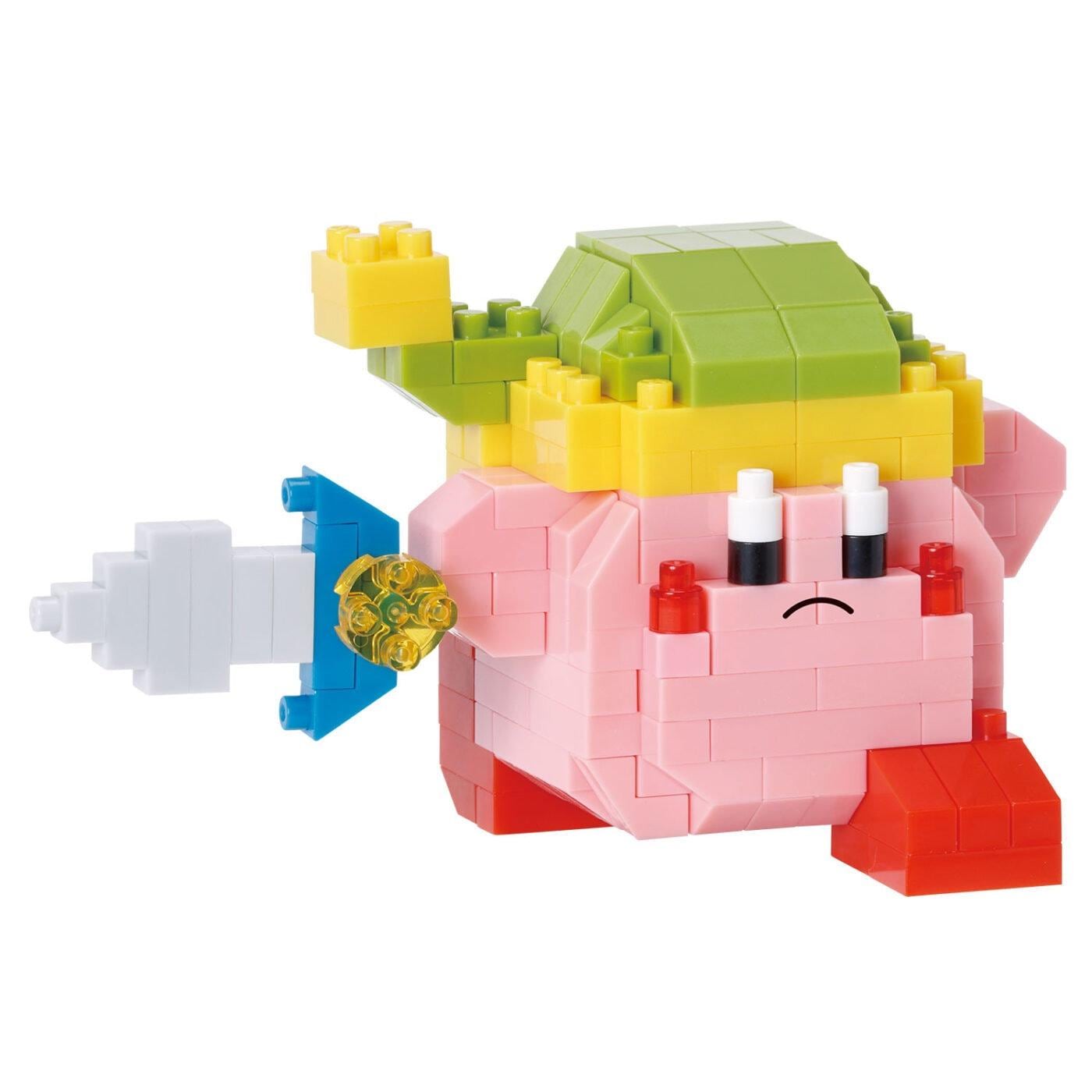 A pink and green toy figurine with a sad expression, made up of various colorful building blocks.