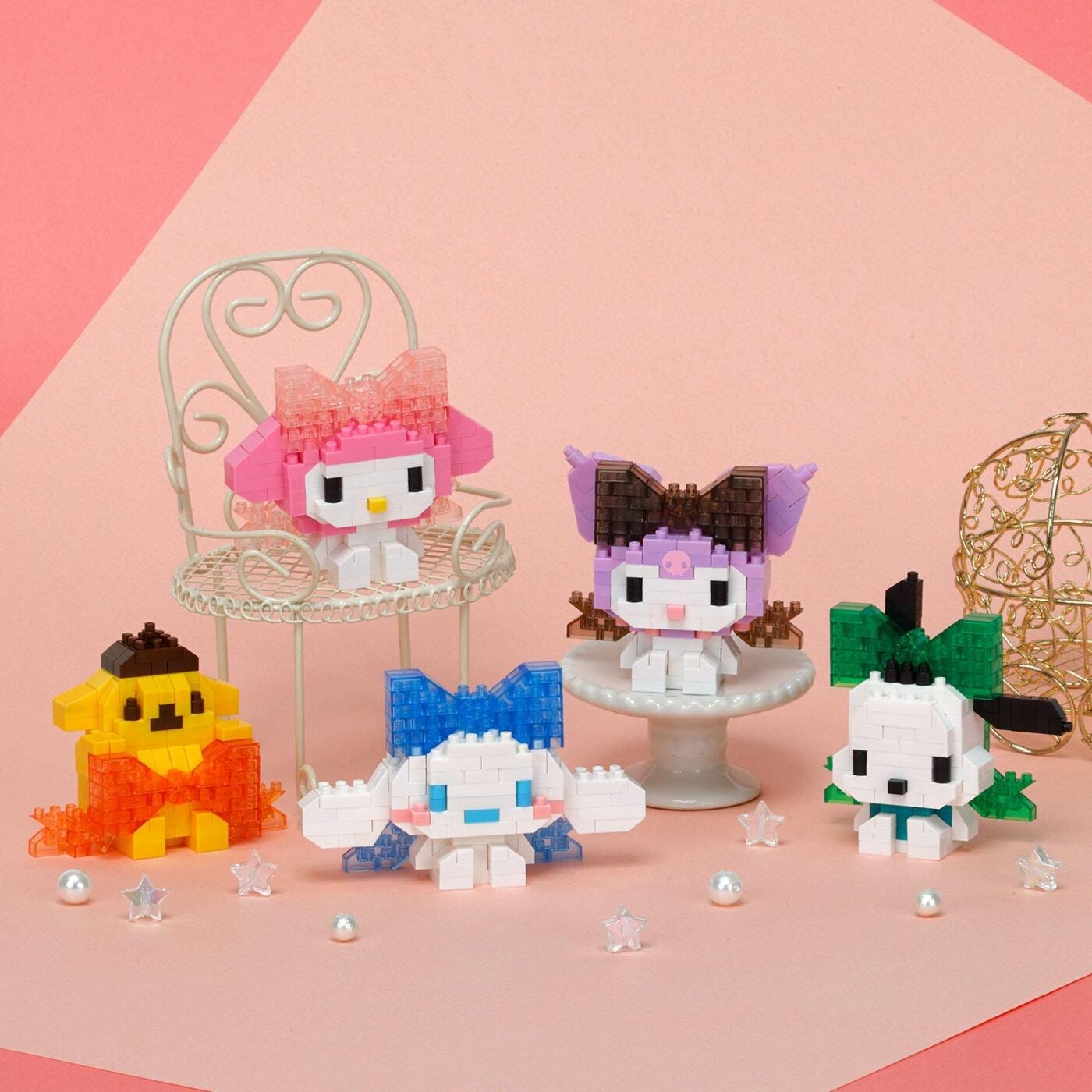 A group of colorful, pixelated characters from the Hello Kitty franchise, including a pink character, a purple character, and other characters, arranged on a pink background.
