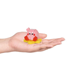 A hand holding a small pink and yellow toy, which appears to be a small figurine or character.