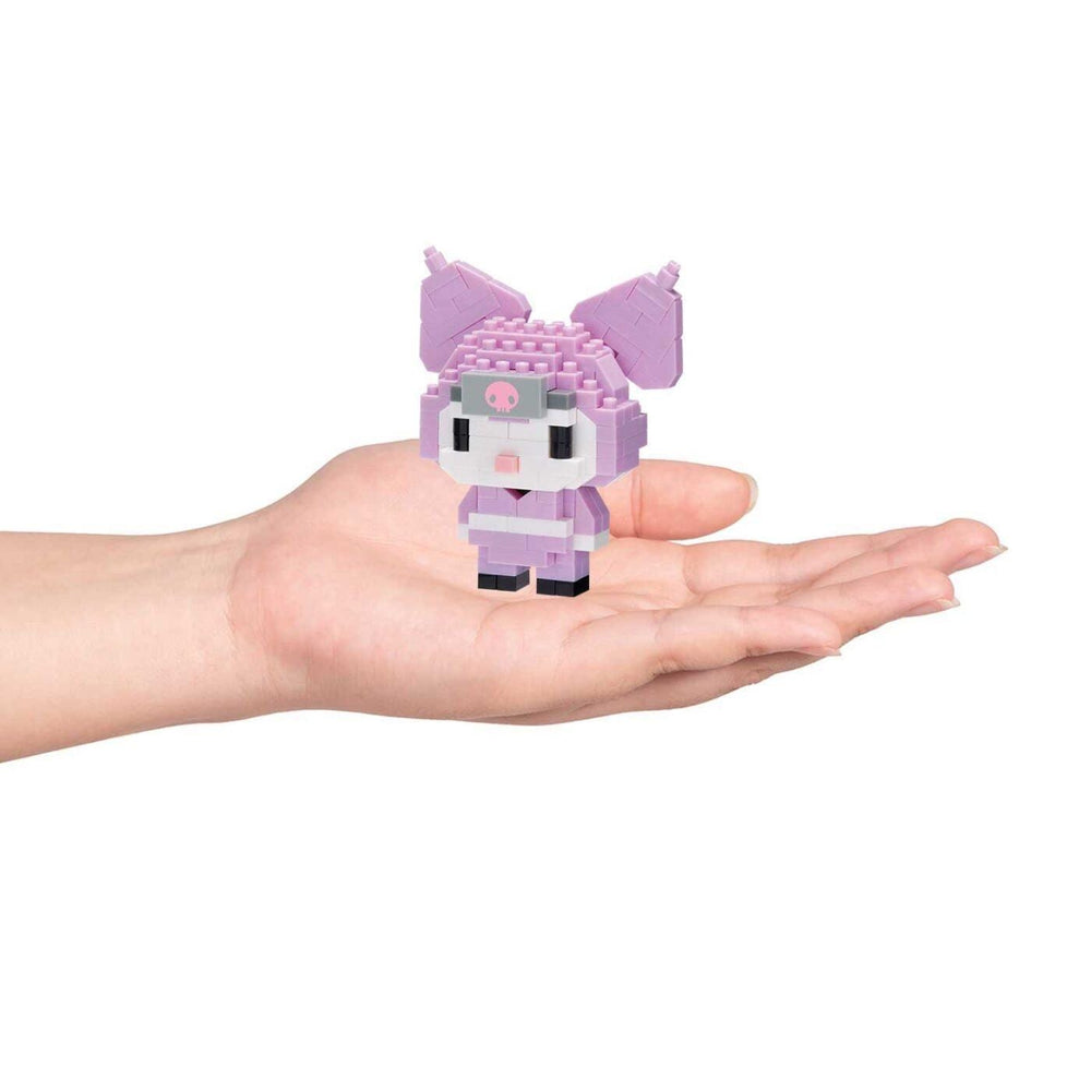 A hand holding a small, pink, pixelated character resembling a character from a video game or animated series.