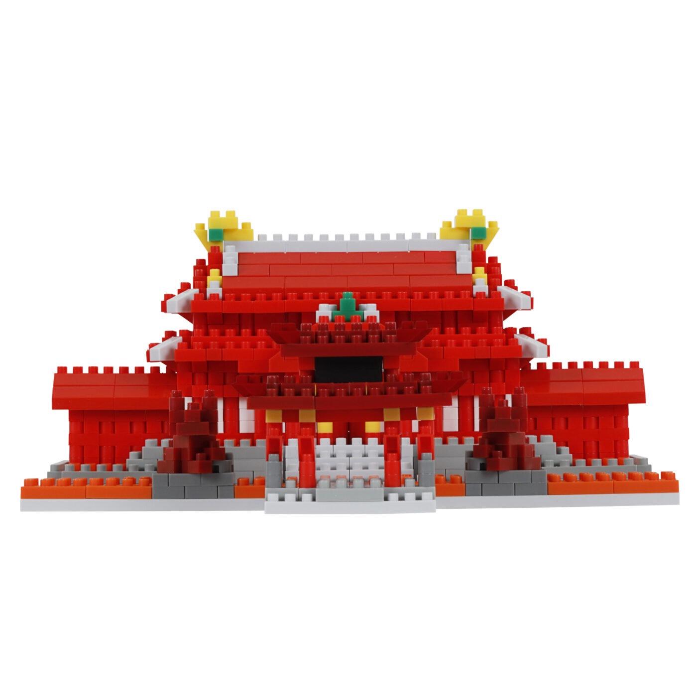 A red and white building made of red and white building blocks, with yellow and green accents, against a white background.