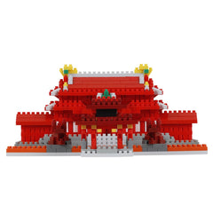 A red and white building made of red and white building blocks, with yellow and green accents, against a white background.