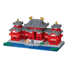 A colorful and intricate model of a temple made of building blocks, featuring red and gray accents, gold accents, and a small figure of a person.