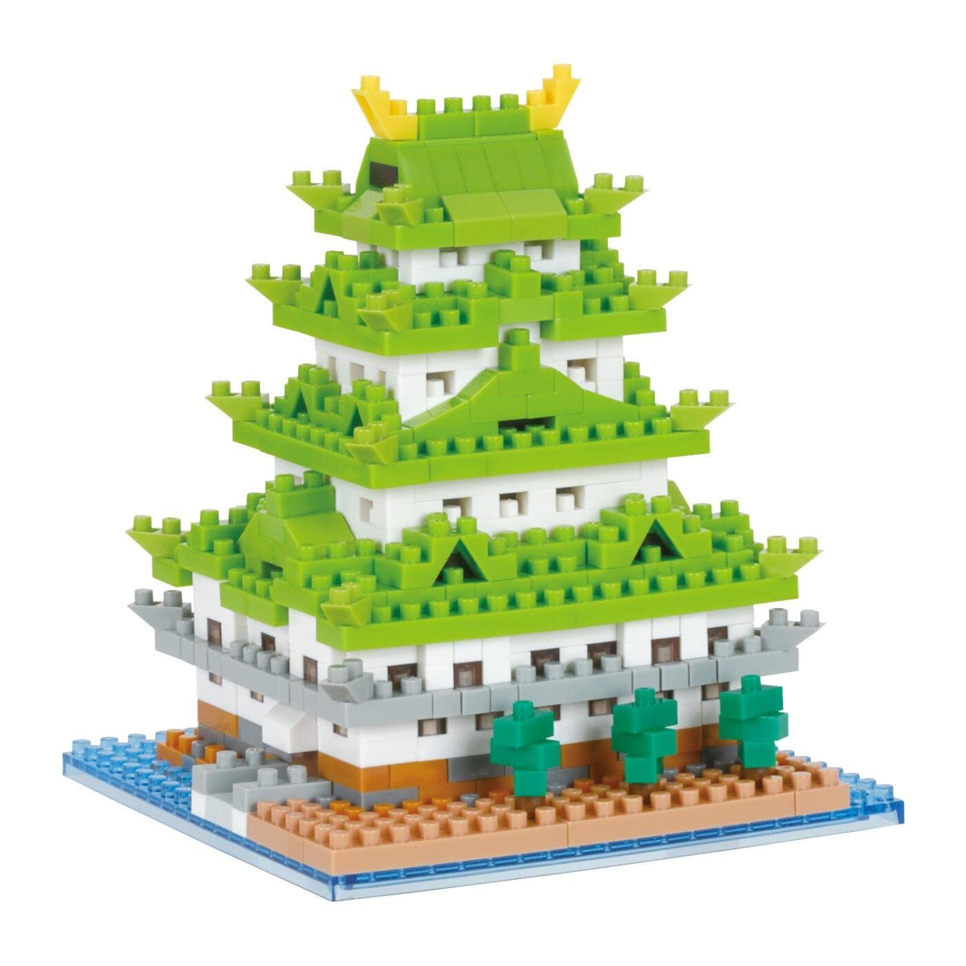 A colorful, three-tiered building made of green and white building blocks, resembling a traditional Japanese temple or pagoda.
