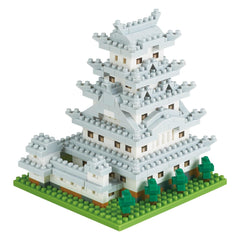 A 3D model of a white castle-like structure made of small white and gray building blocks, set against a green grassy background.