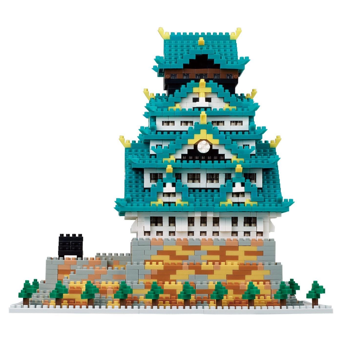 A colorful, intricate, and detailed model of a castle-like structure made of small, interlocking building blocks in various shades of blue, green, and yellow.