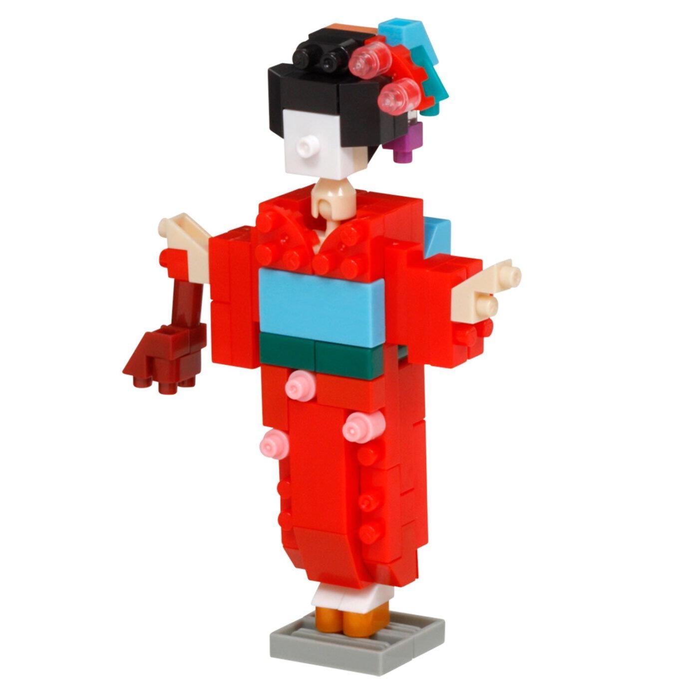 A colorful and whimsical toy figure resembling a geisha, made up of various building blocks in different colors.