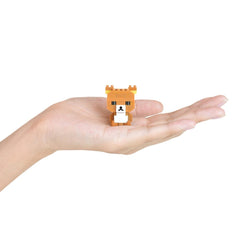 A small, orange-colored toy resembling a bear is being held in a person's hand against a white background.