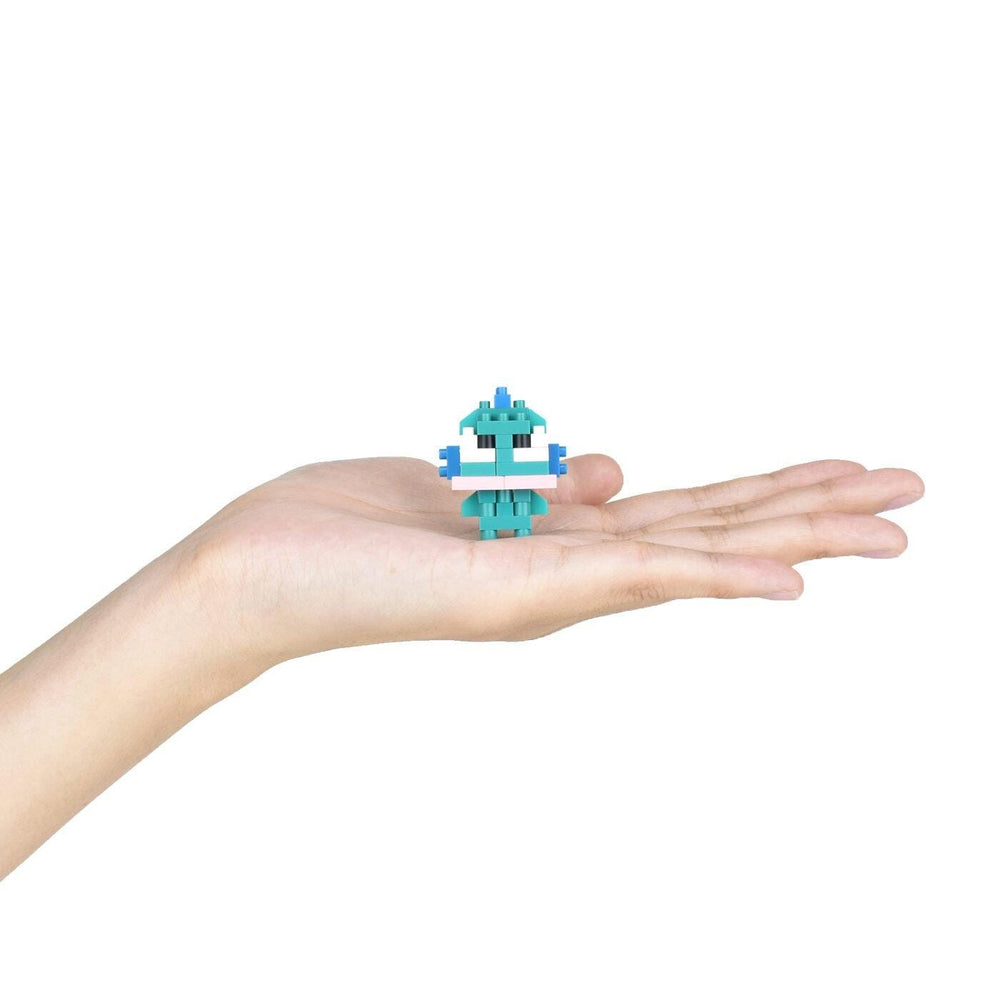 A small, green, pixelated robot figure is being held in a person's hand against a white background.