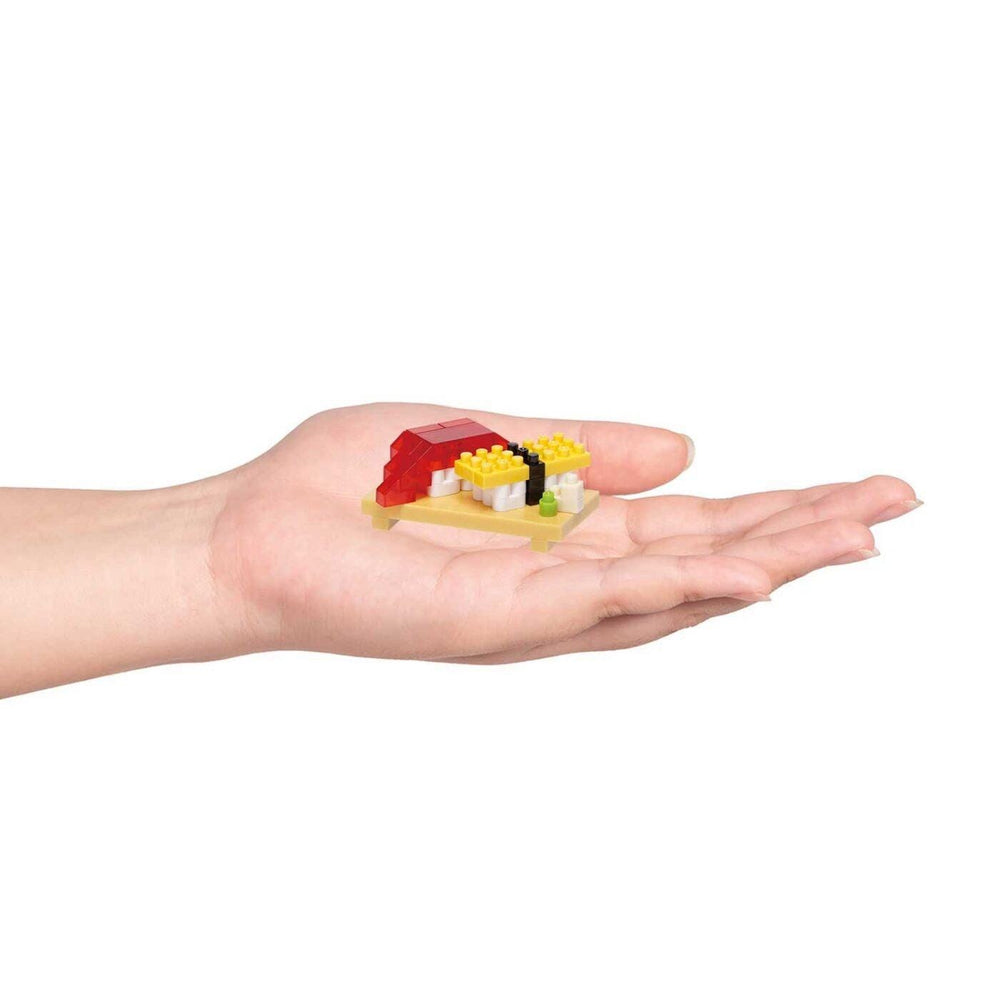 A hand holding a small, colorful object resembling a sushi dish.