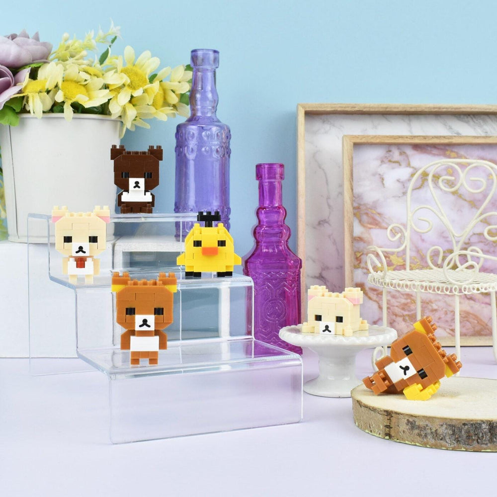 a collection of small, colorful, and whimsical objects, including a miniature bear, a yellow bird, and several other small figures, all displayed on a shelf or table.