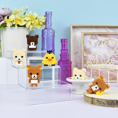 a collection of small, colorful, and whimsical objects, including a miniature bear, a yellow bird, and several other small figures, all displayed on a shelf or table.