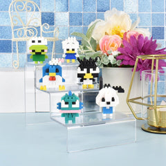 A collection of colorful, pixelated animal figurines displayed on clear stands, with a vase of flowers and a geometric sculpture in the background.