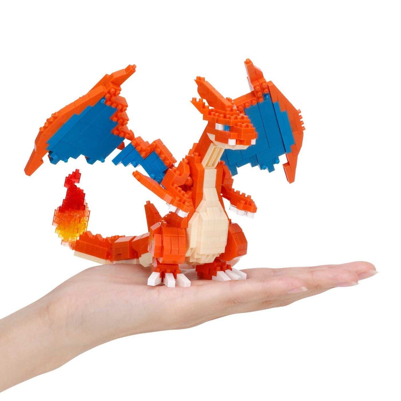 A hand is holding a small, colorful, and detailed LEGO dragon figure.