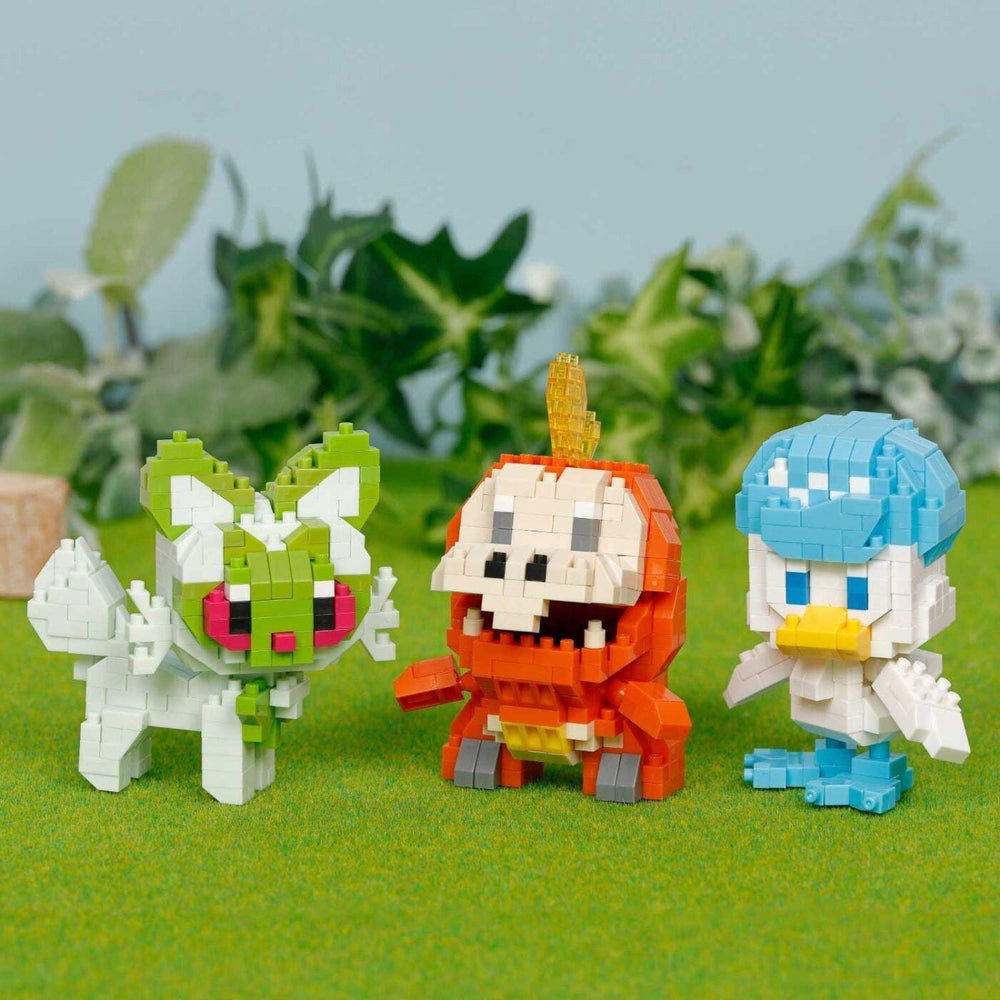 Three colorful, pixelated characters - a green and white creature, an orange and white monster, and a blue and white duck - stand on a grassy surface against a backdrop of green foliage.