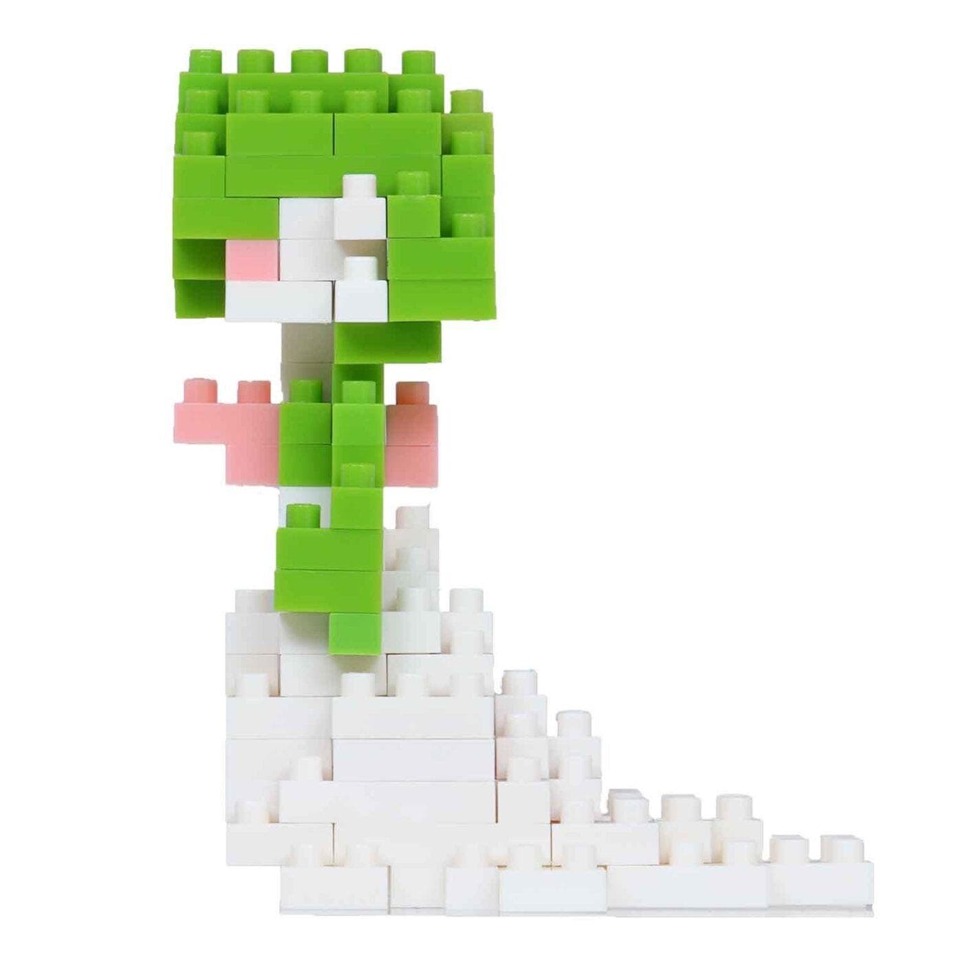 A toy made of small white and green building blocks, resembling a pixelated character or figure.