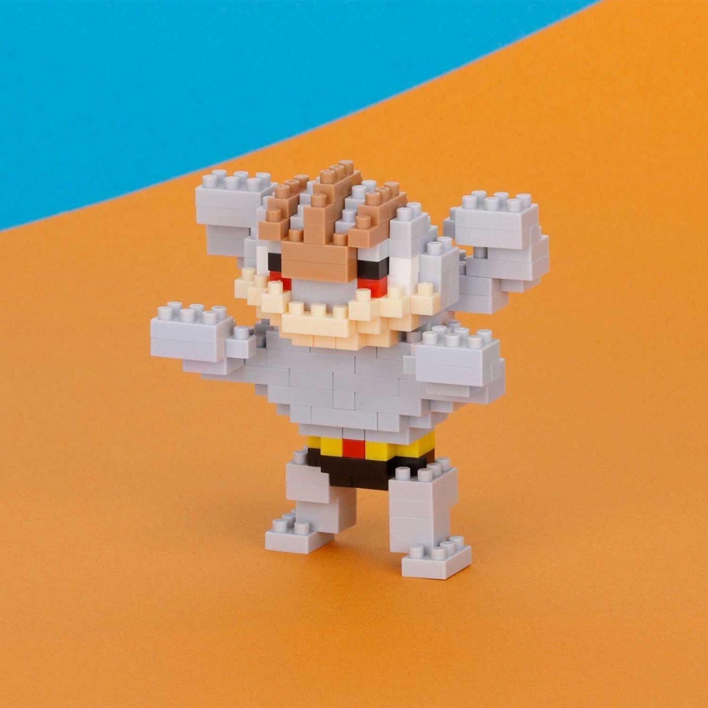 A pixelated Lego figure of a character with a red eye and raised arms, standing on an orange background.