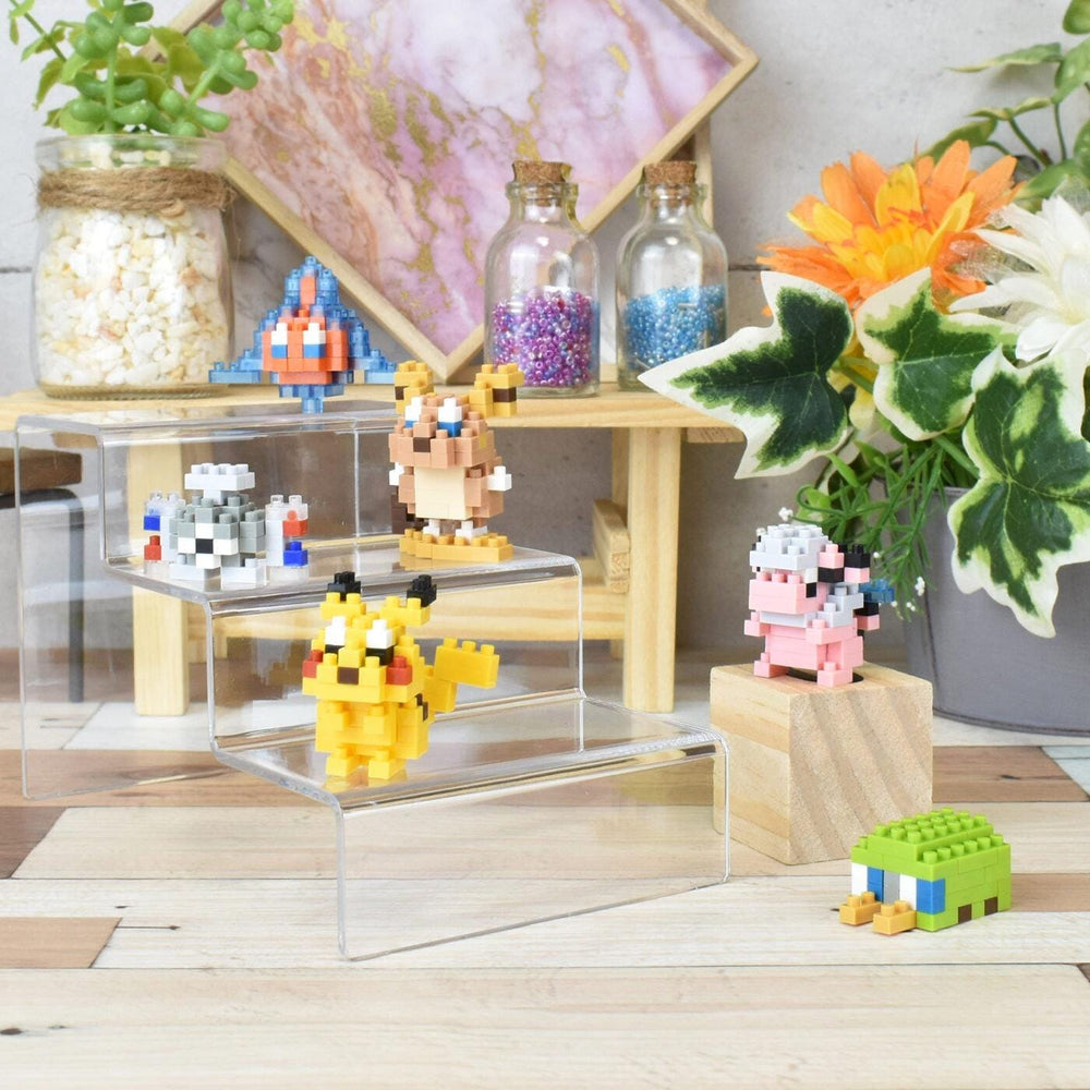 a collection of colorful pixel art figurines and a variety of potted plants arranged on a wooden surface.