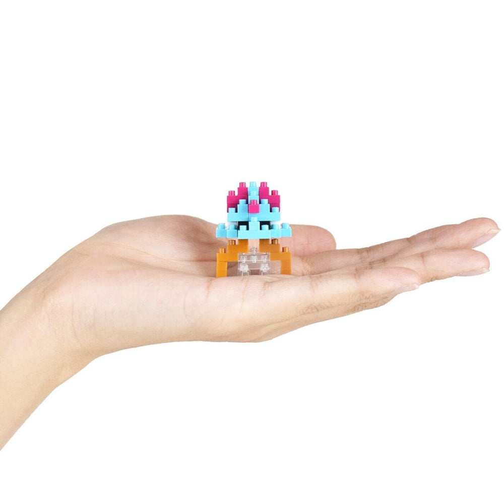 A hand holding a small, colorful, and intricate toy or model.