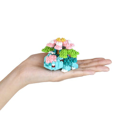 A hand holding a small, colorful, and intricate toy made of small, colorful building blocks.