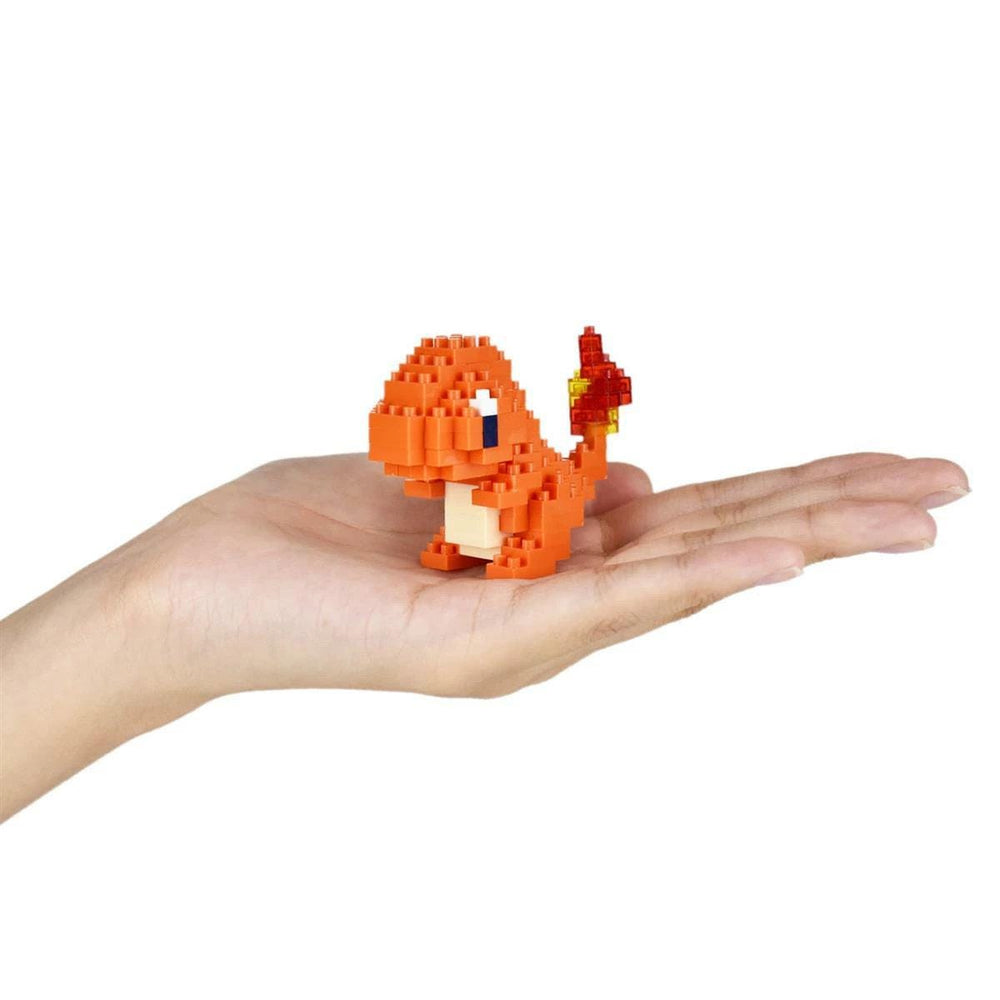 A hand holding a small orange pixelated character, resembling a Pokemon or similar character.