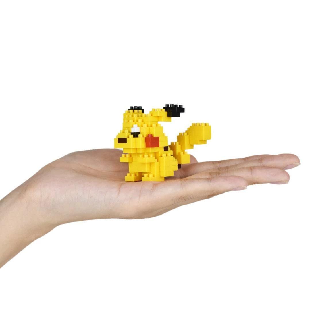 A hand holding a small yellow pixel-based character, resembling a pixel art style Pokemon.