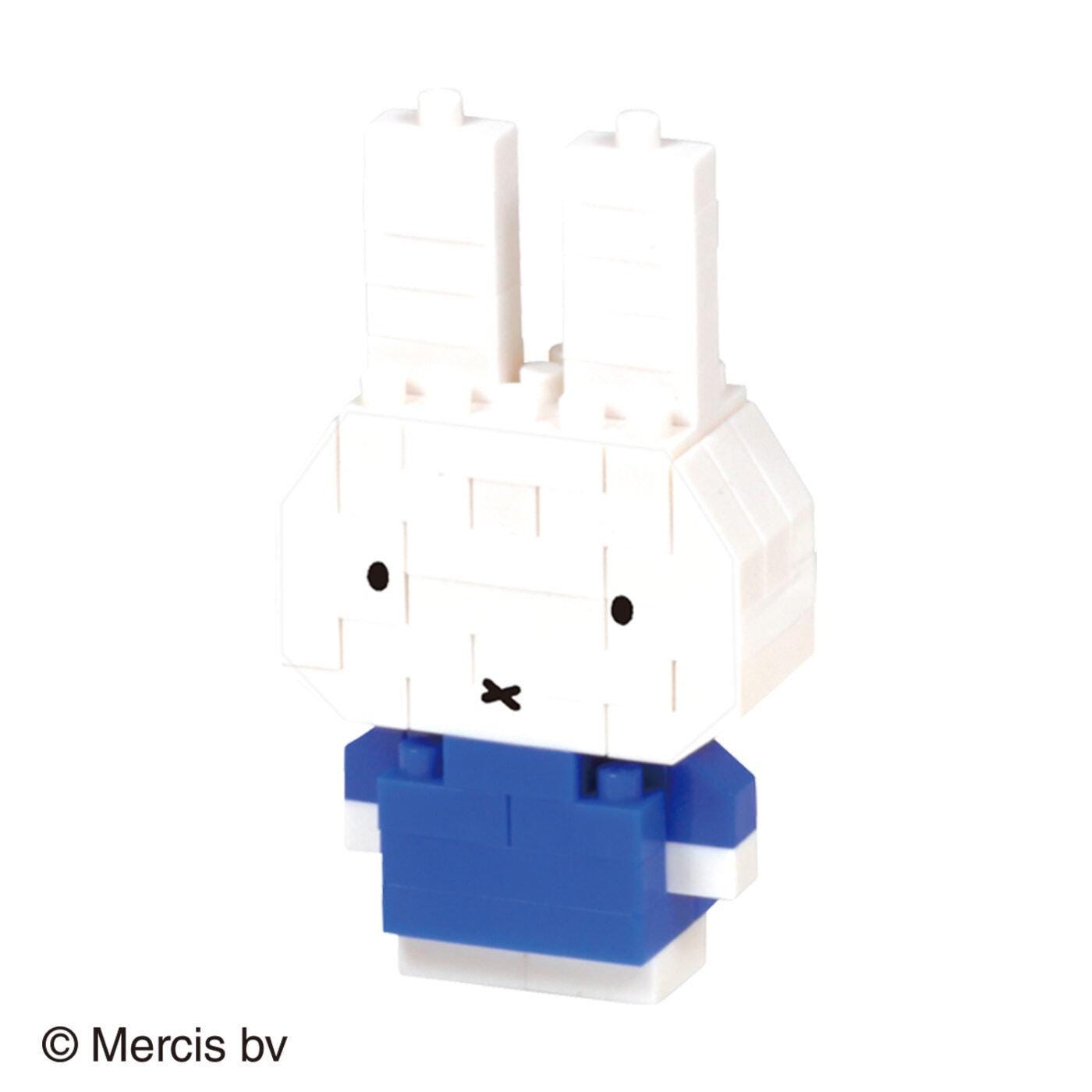 A small, white, and blue toy rabbit with two large ears and a black mouth, standing against a white background.