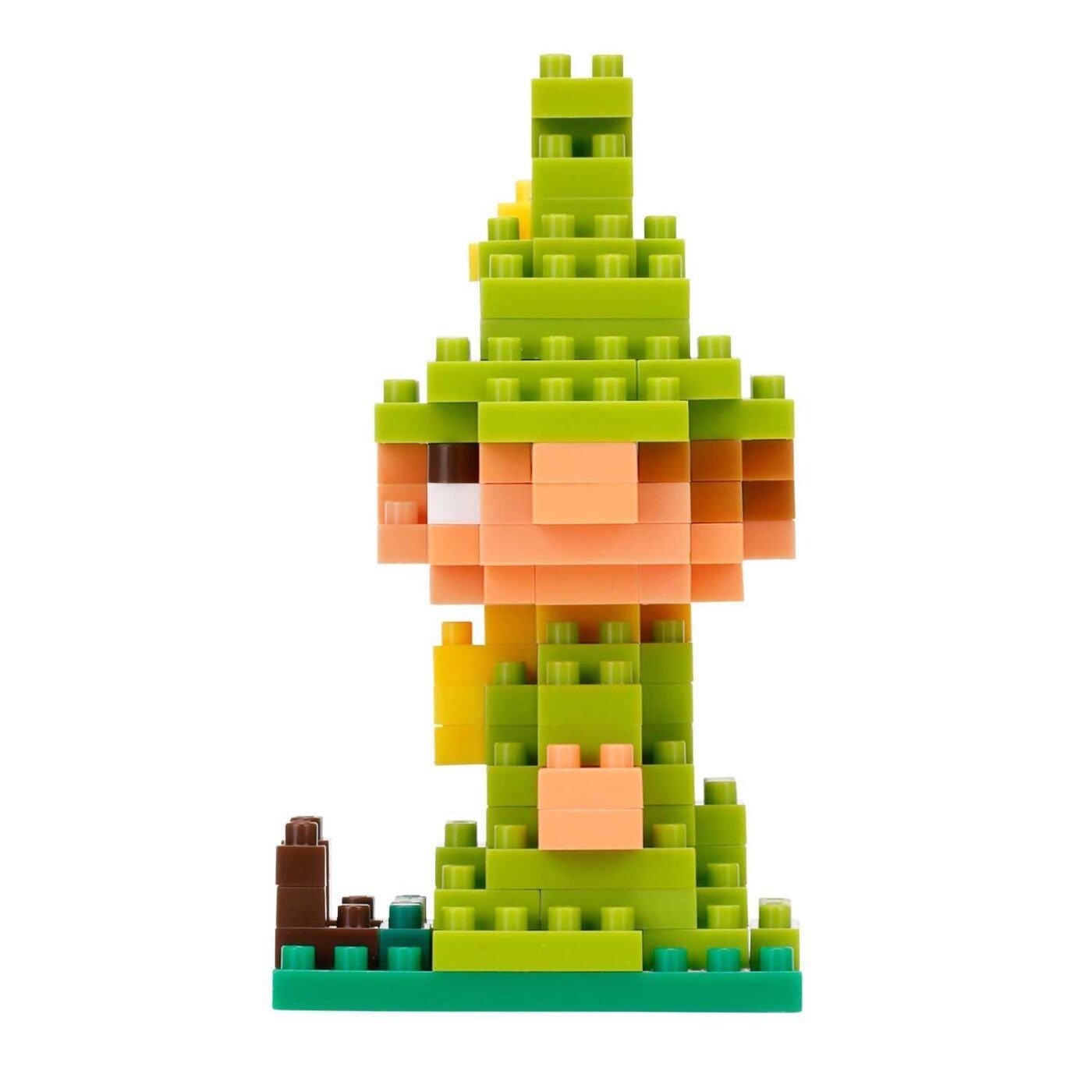 A colorful, pixelated toy resembling a character from a video game or animated film, composed of various green and orange blocks.