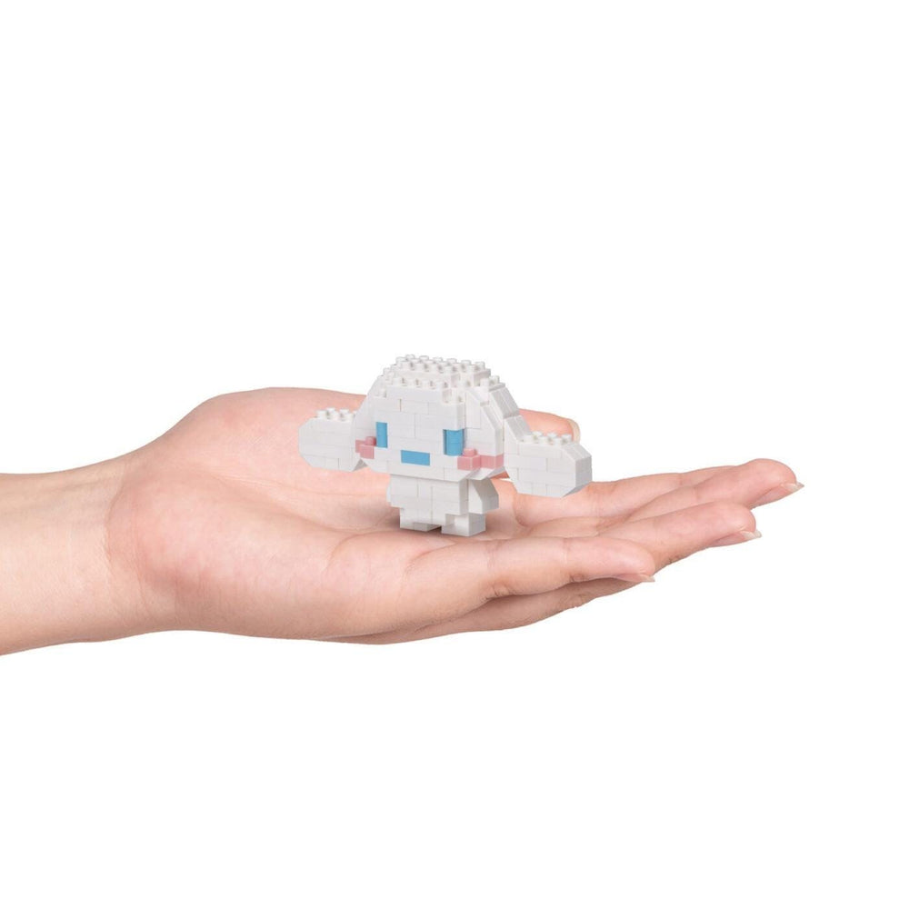 A hand holding a small white, pixelated character with blue accents.