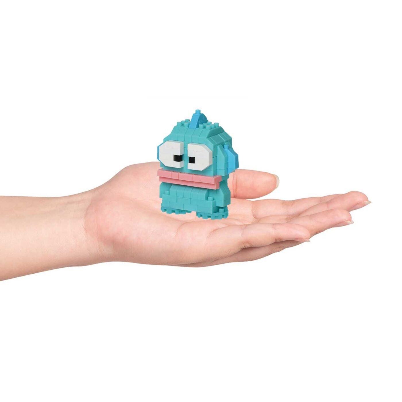 A hand holding a small, colorful, and whimsical toy in the palm.