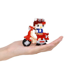 A hand holding a small, colorful, and intricate toy made of building blocks, resembling a Hello Kitty character.