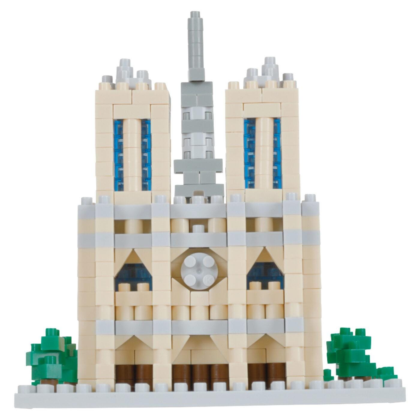 A small, two-story building made of blocks, with blue accents on the windows and a clock on the front.