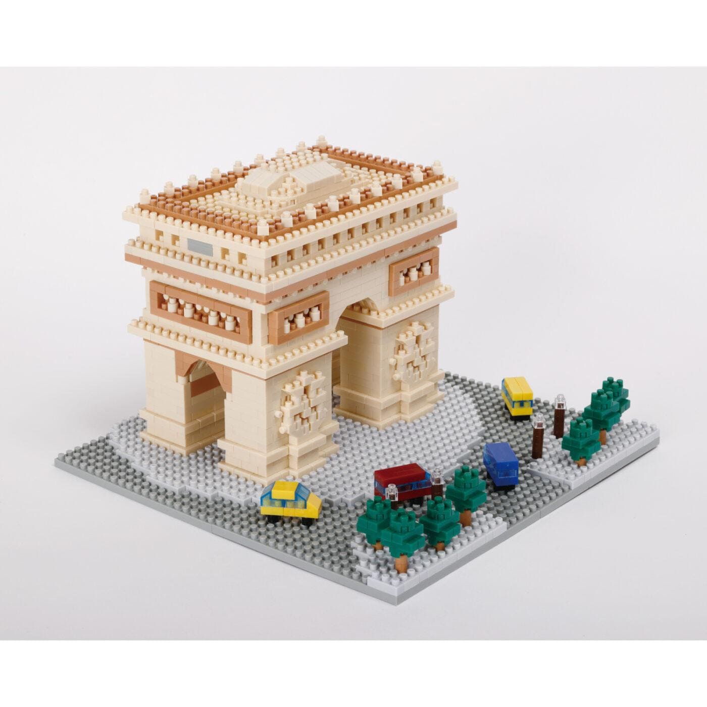 A small, beige-colored building made of Lego bricks, with a yellow taxi and other vehicles in front of it.