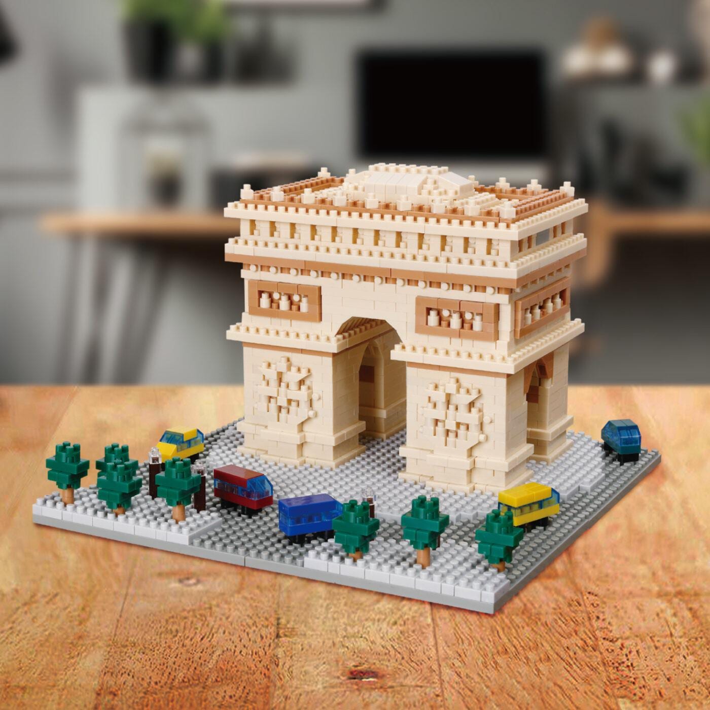 A miniature model of the Eiffel Tower made of building blocks, placed on a wooden surface.