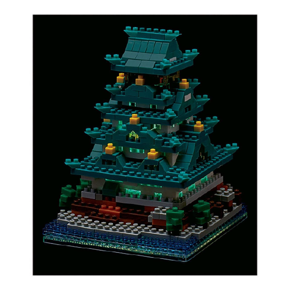 A colorful, multi-tiered Lego castle with intricate details and glowing lights, set against a dark background.
