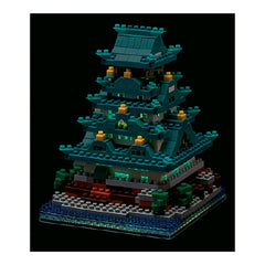 A colorful, multi-tiered Lego castle with intricate details and glowing lights, set against a dark background.