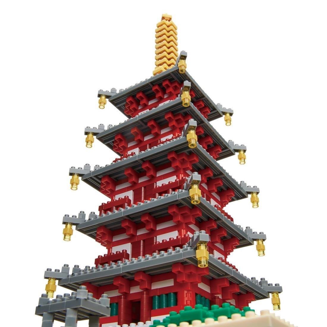 A colorful and intricate model of a traditional Japanese pagoda, composed of numerous small Lego bricks in shades of red, white, and gray.