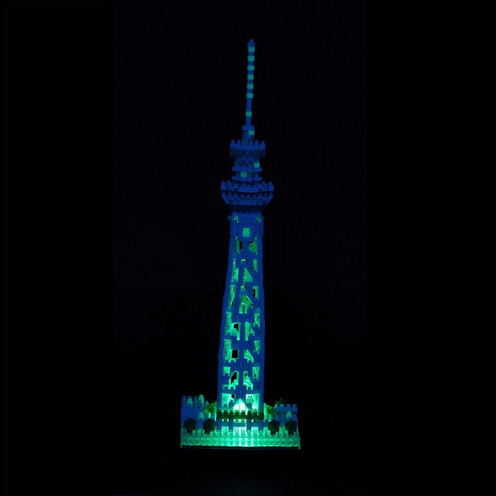 A brightly lit model of the Tokyo Skytree, a famous landmark in Japan, stands prominently against a dark background.