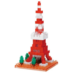 A red and white Lego tower made of small Lego bricks, with a few green Lego trees in the foreground.