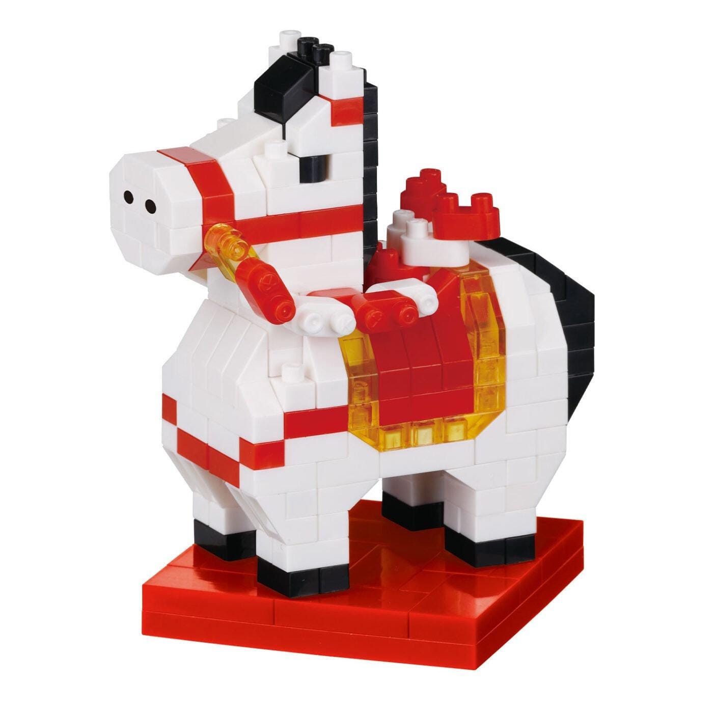 A toy horse made of colorful building blocks, including red, white, and black pieces, standing on a red base.