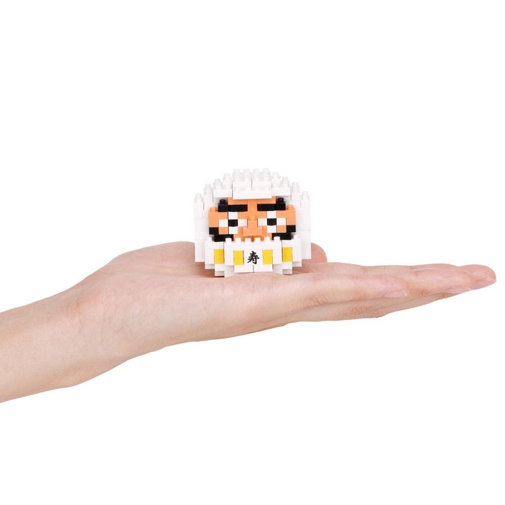 A hand holding a small, pixelated character resembling a face or a doll.